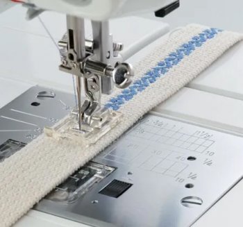 Transparent Janome applikationsfot F i klarplast för symaskin. Sulan har en urfasad undersida för tät sicksack samt röda markeri
